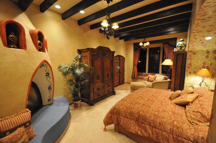 ห้องนอนใหญ่ขนาดใหญ่พร้อมเตียงคิงไซส์เตาผิงที่นั่งศูนย์ความบันเทิงและทางเข้าดาดฟ้า