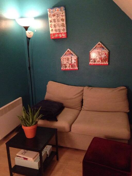 salon avec grande fenêtre qui donne sur les toits de Paris