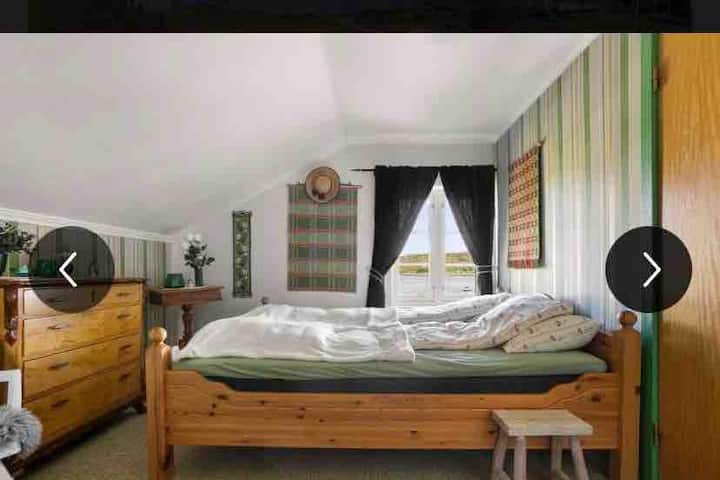 Spálňa s manželskou posteľou s výhľadom na fjord.