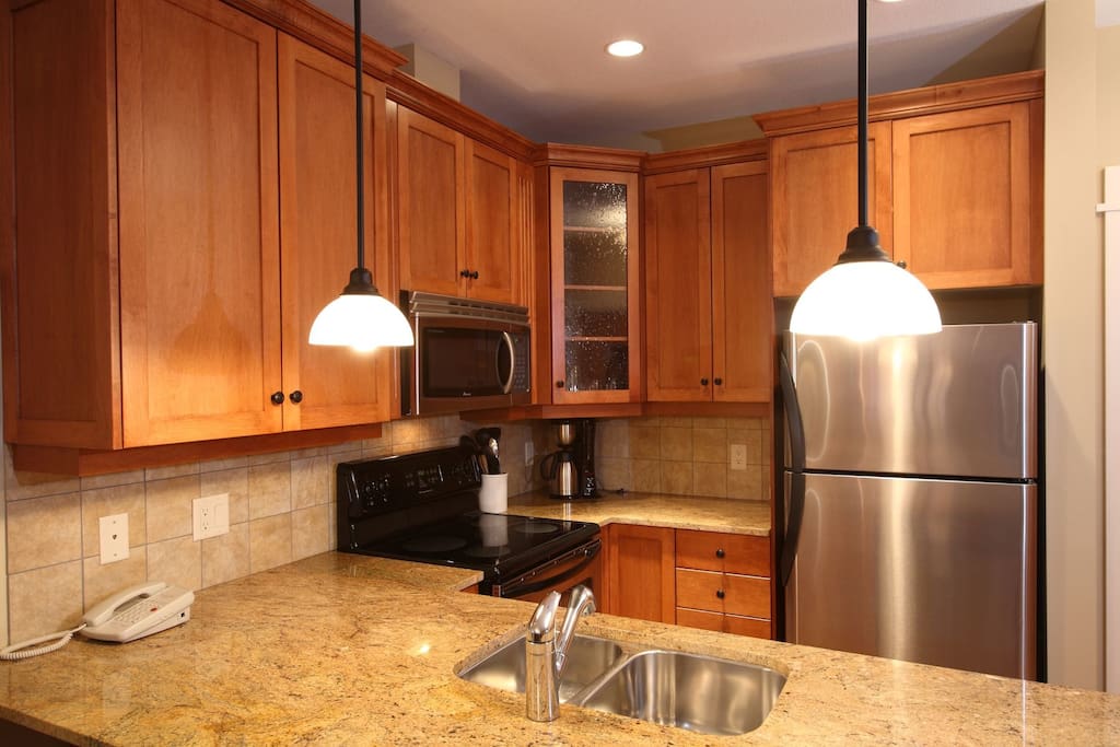 The gourmet kitchen features granite countertops and stainless steel appliances