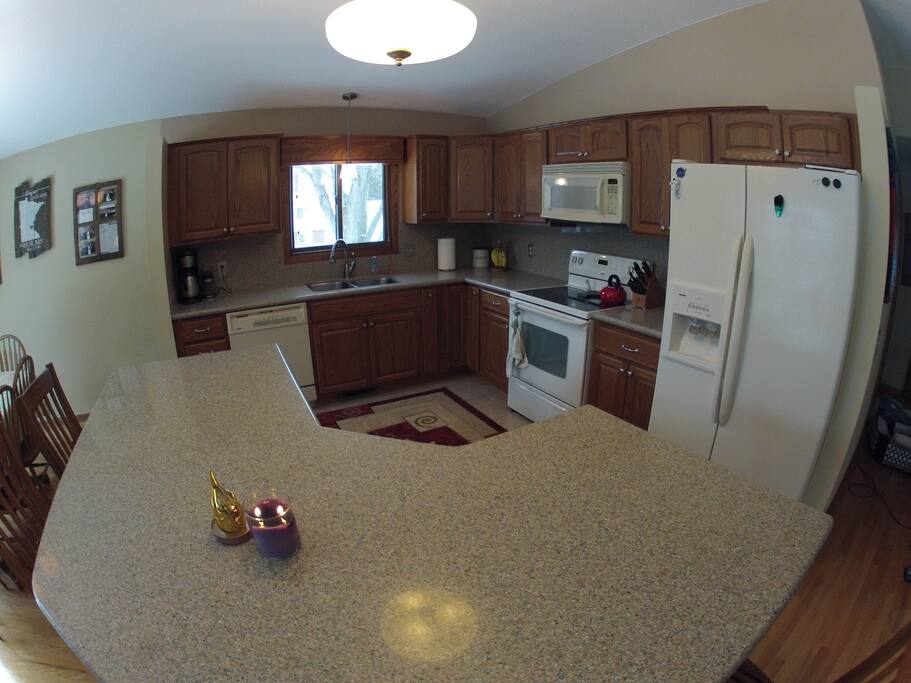 A full kitchen with all the dinnerware, appliances and cookware.