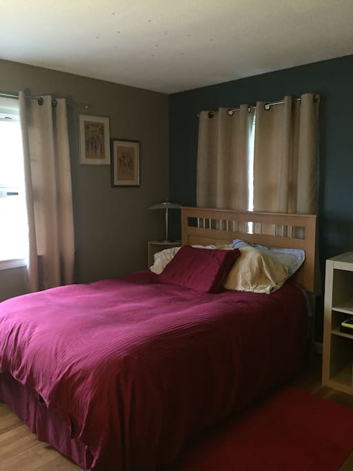 Double-size bed with 2 outlets nearby for charging devices.