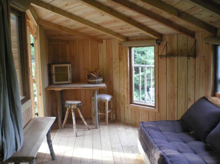 La pièce unique de la cabane avec la banquette litpieLa
