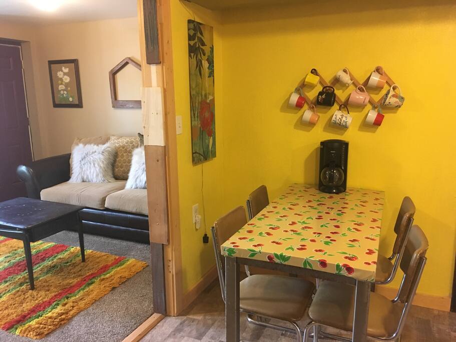 Living room with TV and DVD player attached to kitchen.