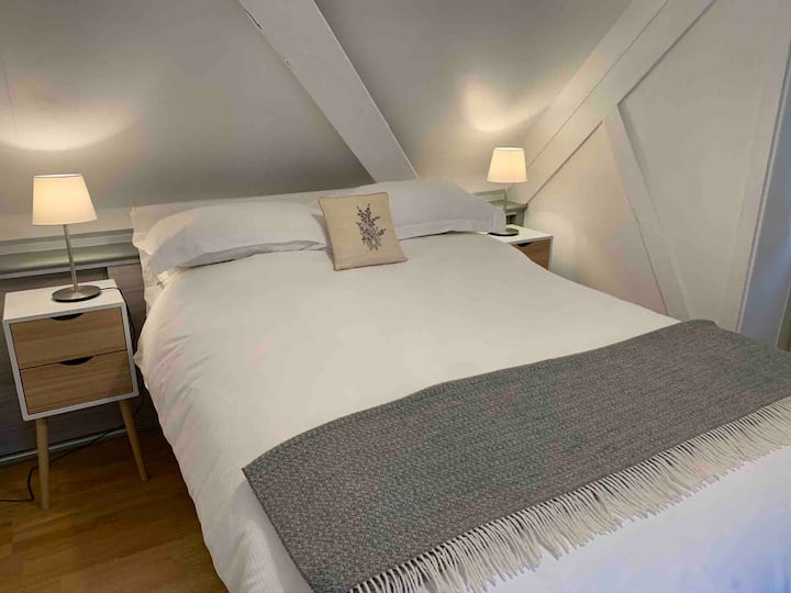 舒适温馨的卧室，配备标准双人床和抽屉里的吹风机。 插头插座包括用于电子产品充电的USB连接。