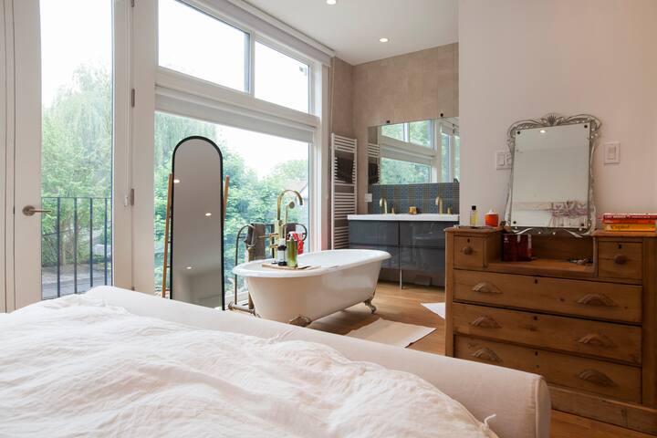 חדר שינה ראשי בקומה השלישית עם מיטת קינג - נוף לחדר הרחצה מהמיטה.