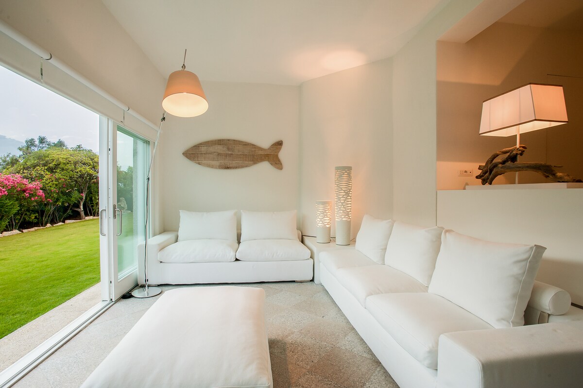 Dnevni boravak u prizemlju s velikim kliznim prozorom iznad vrta s engleskom travom