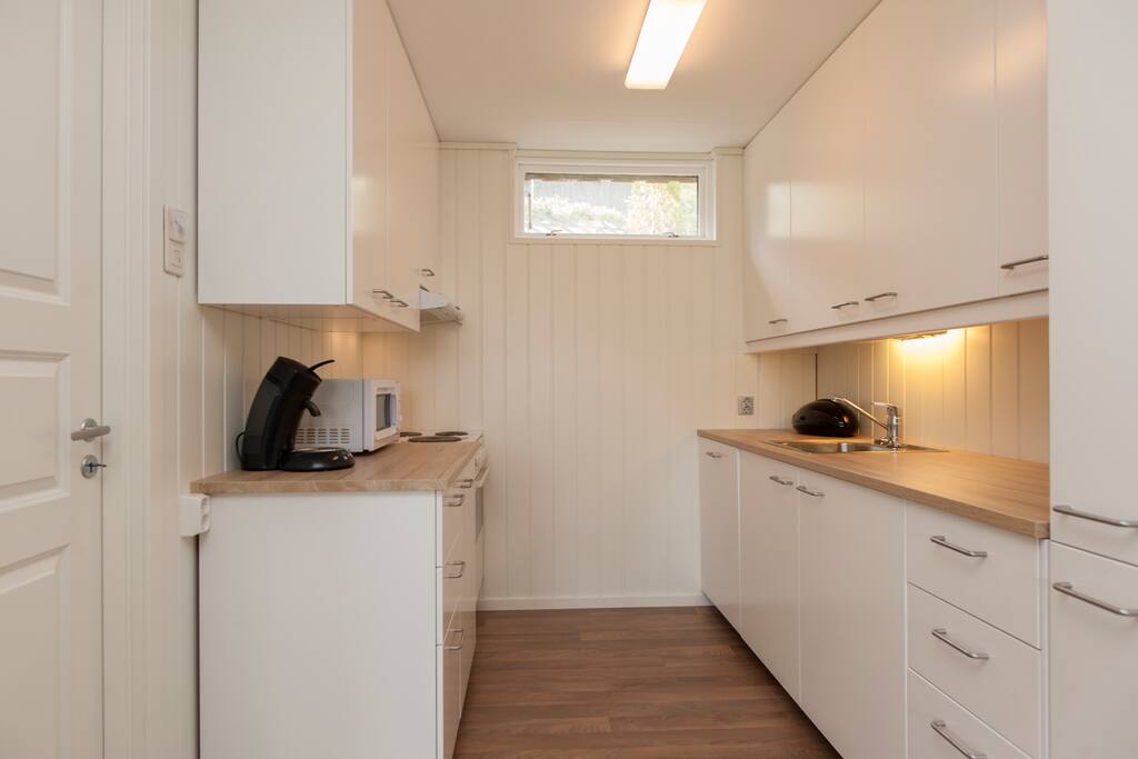 Kjøkken med integrert kjøleskap/fryser og oppvaskmaskin. Alt av kjøkkenutstyr i skuffer og skap. The kitchen is fully equipped, with integrated fridge/freezer and dishwasher.