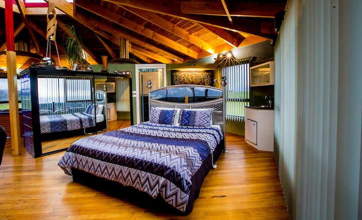 Chambre principale à l'étage avec lumière du ciel vers le ciel nocturne.