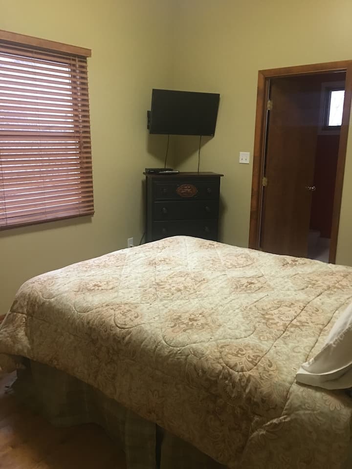 dormitorio delantero con televisión y baño adjunto