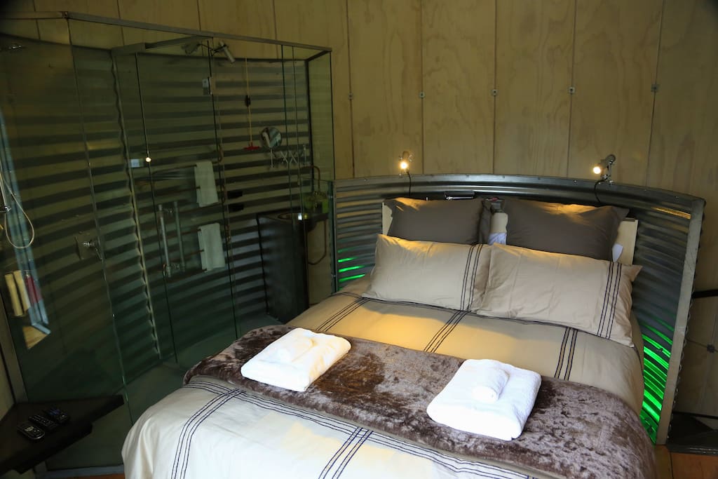 Queen bed and ensuite behind curved glass wall