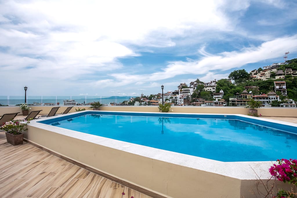 Sunny rooftop pool with views of the City and Banderas Bay