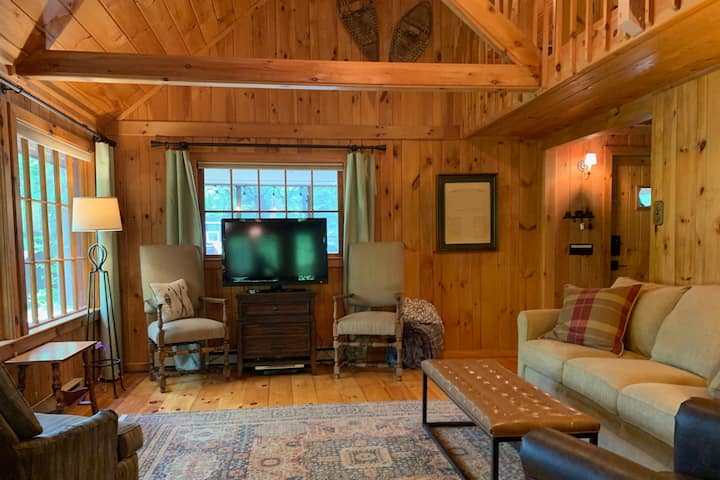 This knotty pine rustic cabin is tucked away on a tree-filled  acreage lining a private lakefront and sand beach just steps away from the front door.