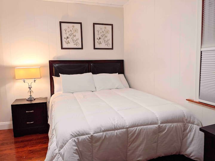 This is the second bedroom, with a smart TV on the wall opposite the bed. 