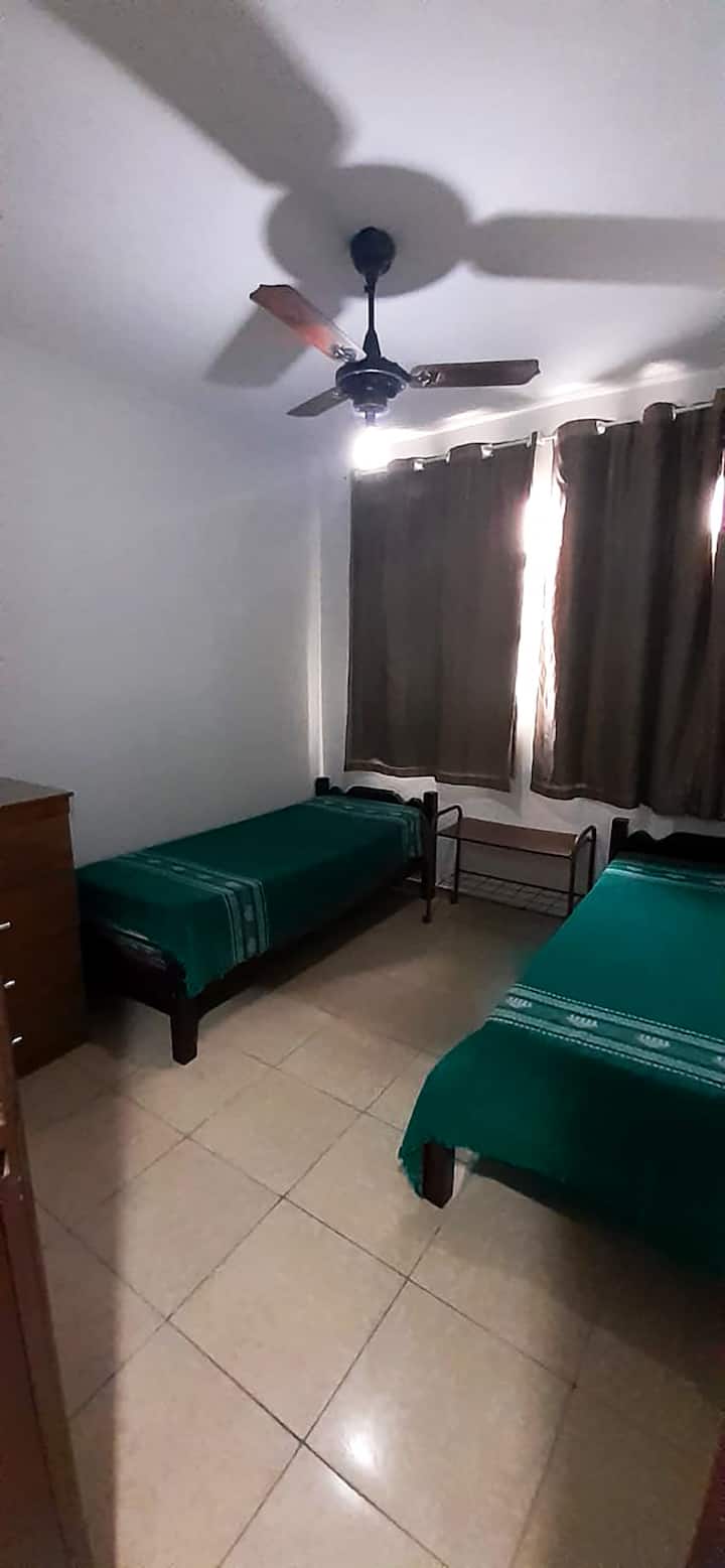 O segundo quarto está equipado com uma cama queen size e uma cama de solteiro