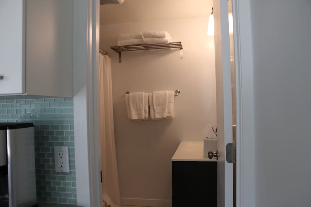 A full bath with white linens.