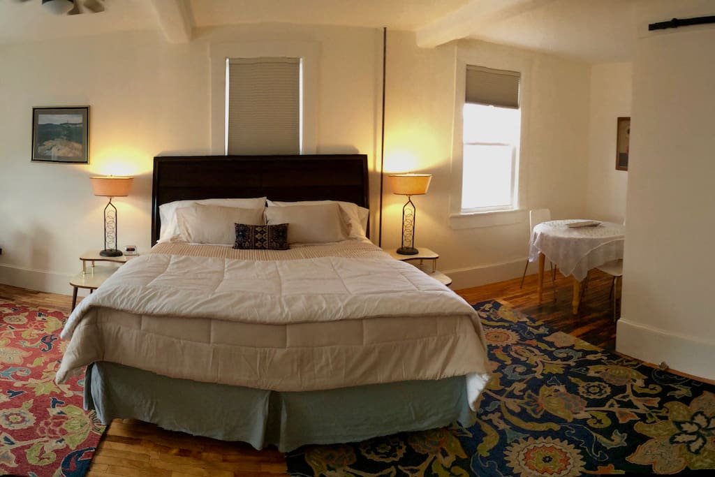 View of bed with dining nook on right.