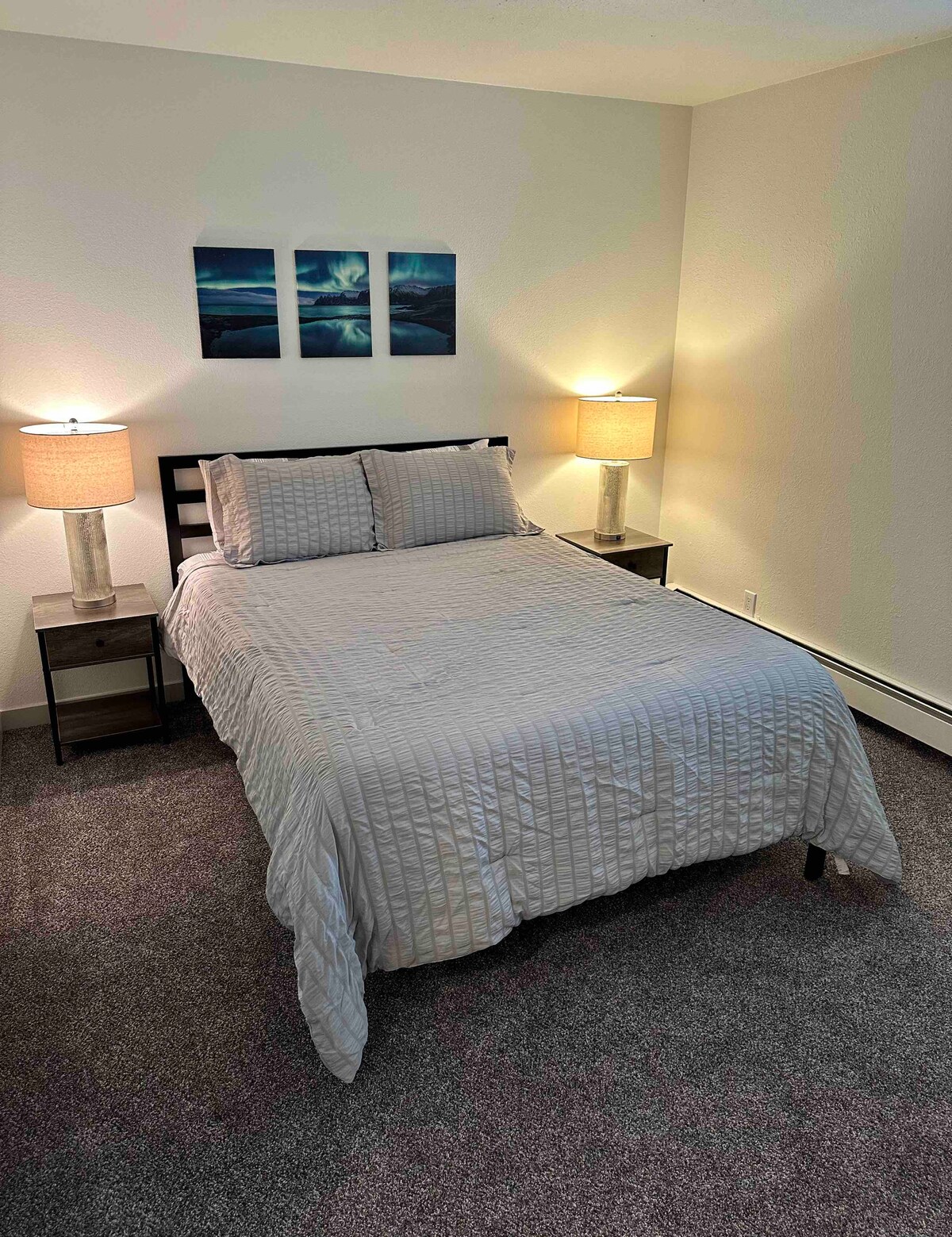 พักผ่อนอย่างสบายบนเตียงขนาดควีนไซส์พร้อมผ้าปูที่นอนนุ่มสบาย โคมไฟข้างเตียง เครื่องเสียง และตู้เสื้อผ้าขนาดใหญ่พร้อมไม้แขวนเสื้อและเครื่องนอนเพิ่มเติม