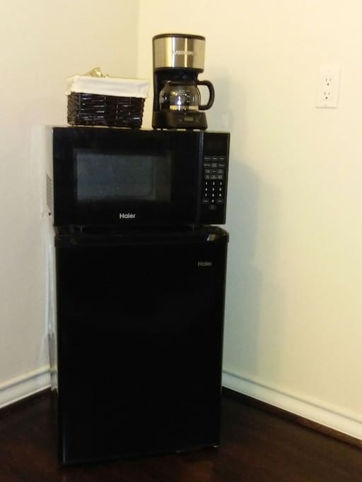 Microwave, mini-fridge, coffee maker, and coffee and tea selection provided.