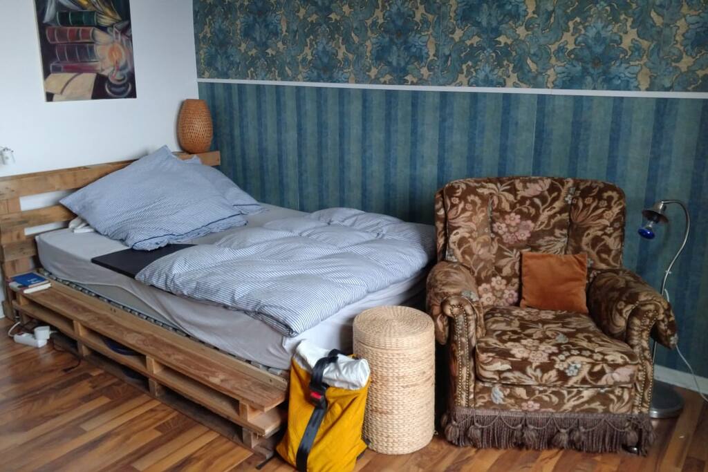 Bett mit gemütlichem Sessel und neuer Tapete