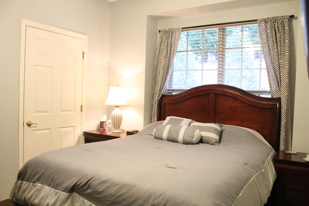 Queen sized bed in guest room with adjacent private bathroom.