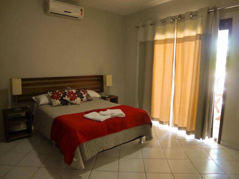 Quarto 01 com acesso privado à varanda.