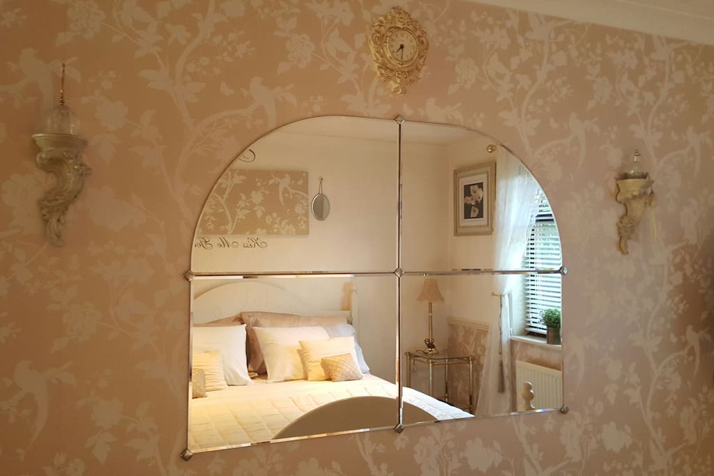 Large beveled edge mirror opposite king size bed.