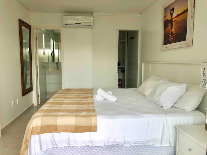 Suíte com cama king size, closet e banheiro.