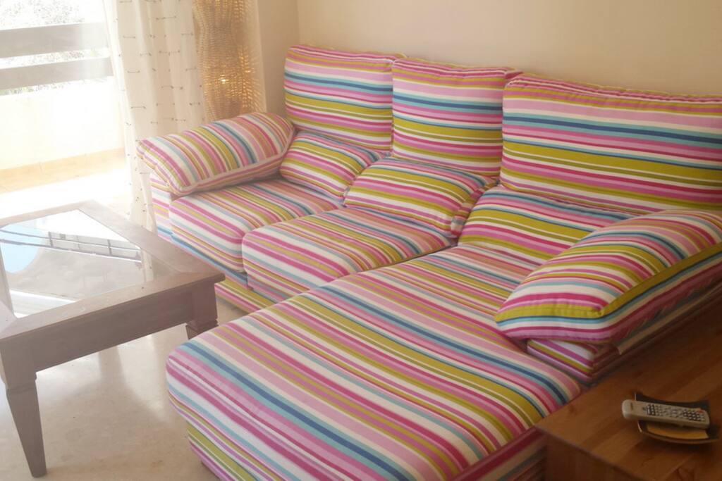 Un sofá chaise long muy alegre super cómodo en el que descansar..