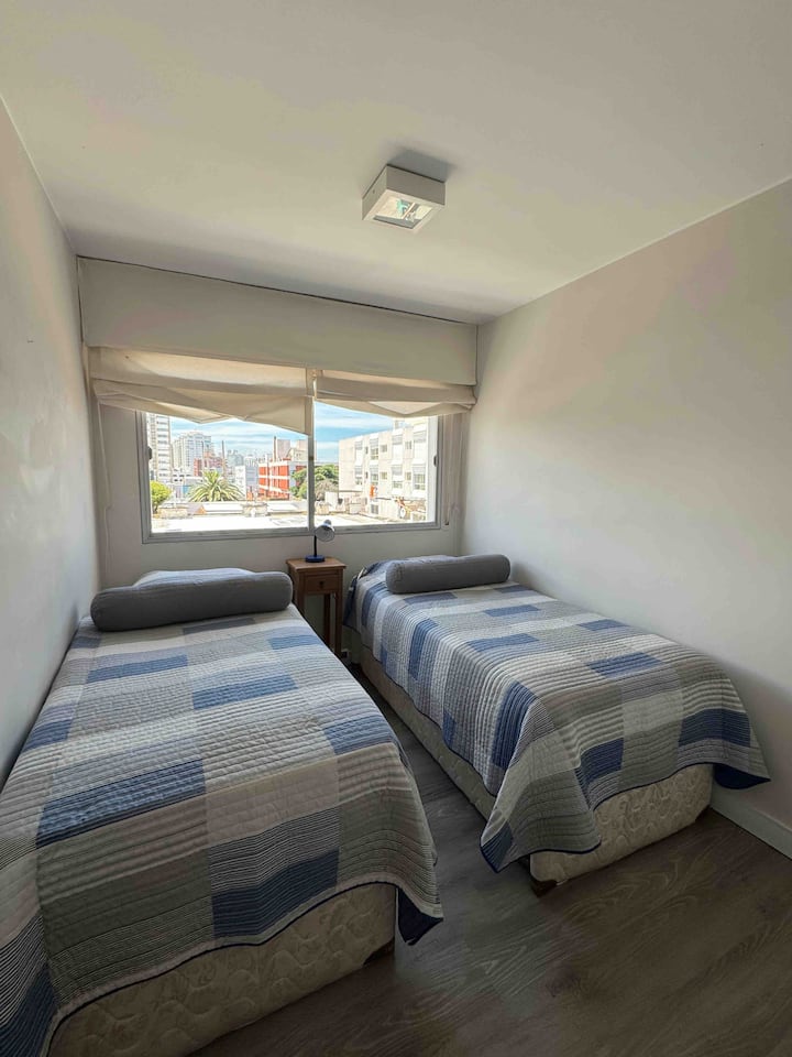 Habitación con dos cómodas camas individuales, armario para guardar la ropa.