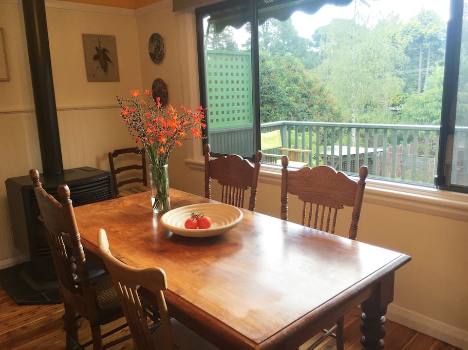 The dining table seats six and overlooks the garden and the bush beyond.