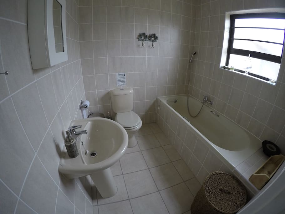 Full bathroom with bath and shower head.