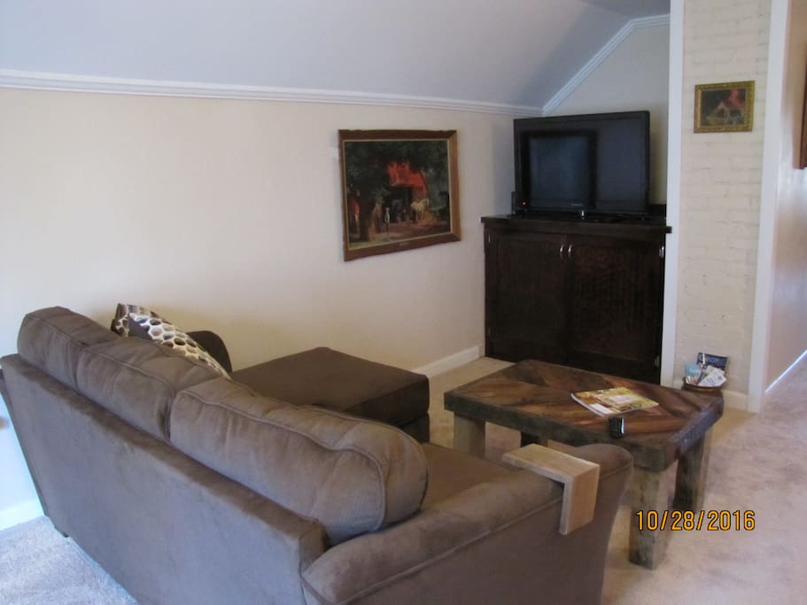 Comfortable couch and a 40 inch flat-screen TV with cable.