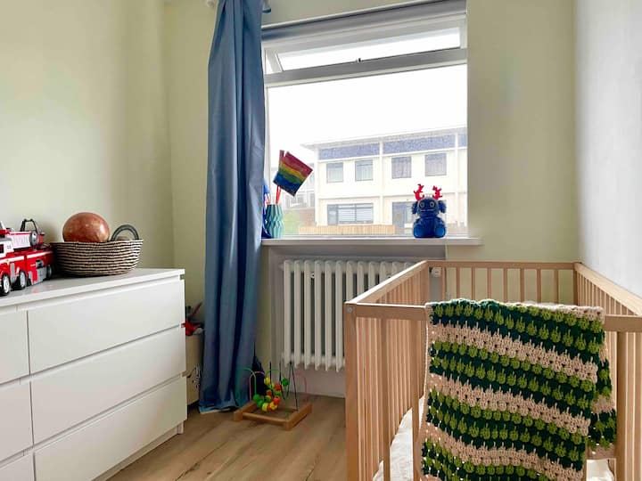 غرفة نوم للأطفال الصغار مع سرير أطفال ومنطقة لعب