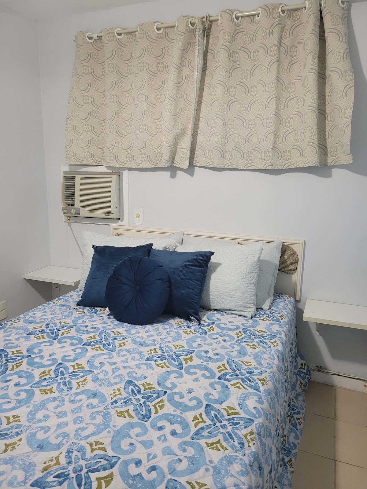 Quarto com cama de casal e ar condicionado.