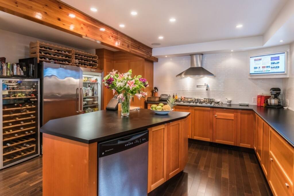 Open Chef's Kitchen w/ gas range, oven, commercial fridge & freezer, drinks cooler, double sink, utility island and dishwasher. Great for communal food preparation.