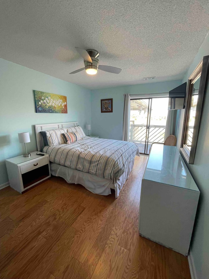 ห้องนอนหลักพร้อมเตียงควีนไซส์และสมาร์ททีวี