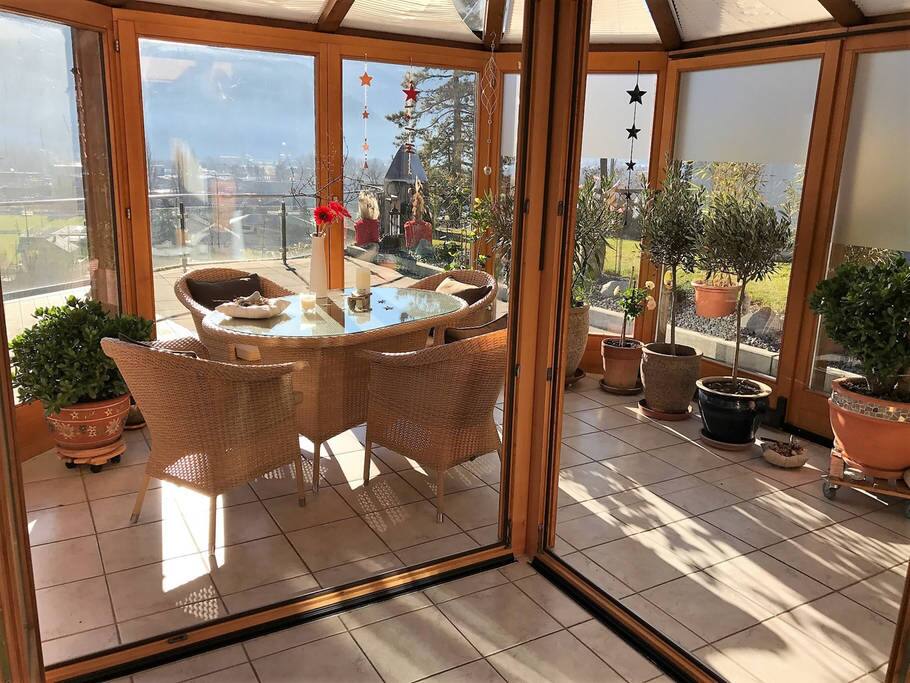 Sonniger Wintergarten verbindet das offene Wohnzimmer mit der grossen Terasse | The sunny winter garden connects the open living room with the big terrace