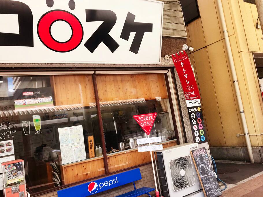 本通り沿いにあるたこ焼きコロスケの大きな看板、クトマレのフラッグが入り口の目印です