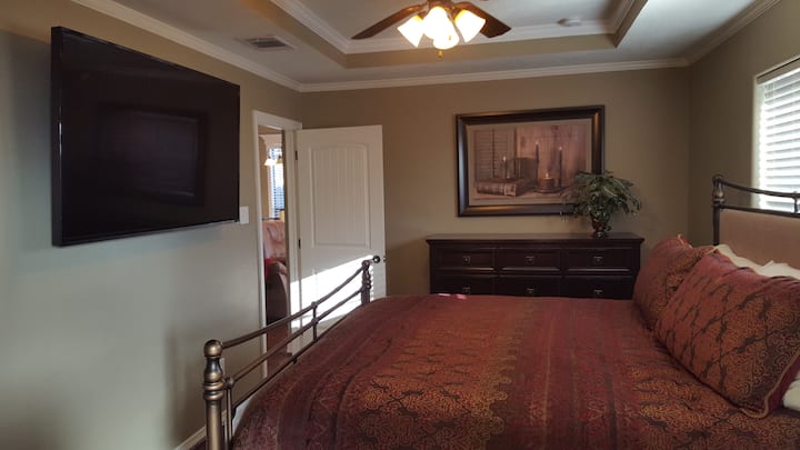 Glavna spavaća soba s madracem King size Beautyrest Black Collection i televizorom od 65 inča.