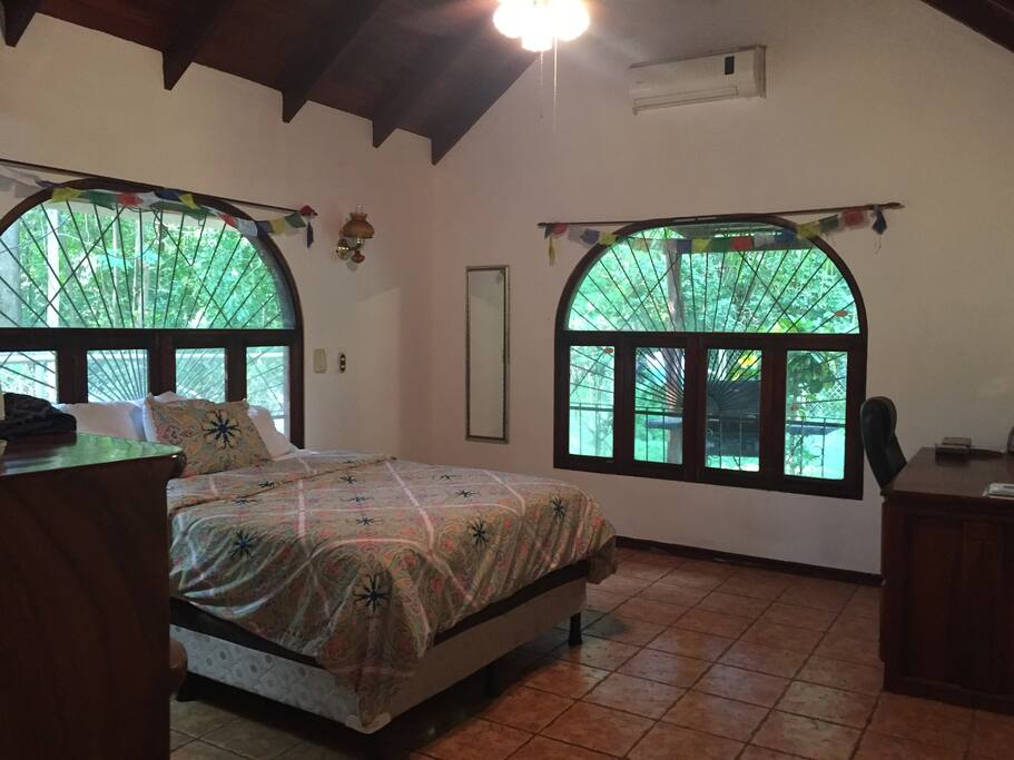 Large master bedroom with high native wood ceilings, round windows