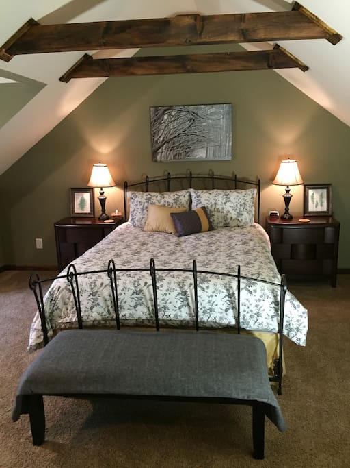 Your bedroom, with lamps, night stands, and a bench for your luggage.