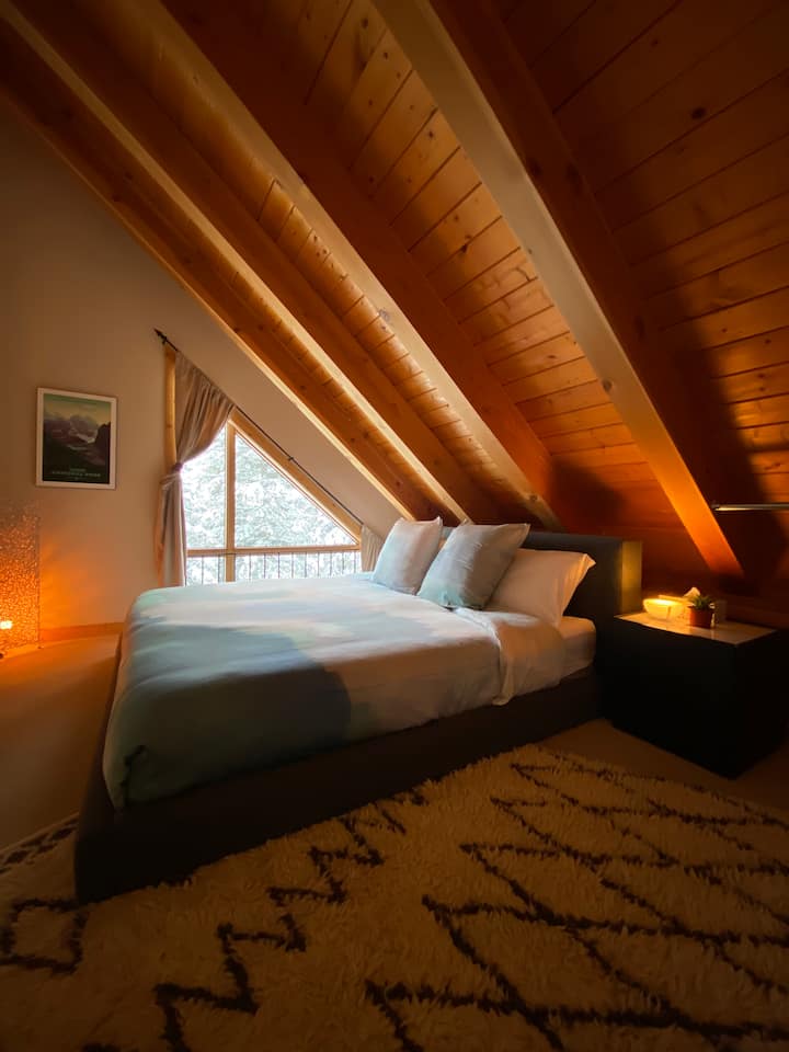 Slope-style bedroom #4. One king bed and one twin. Cozy room with character and romantic lighting