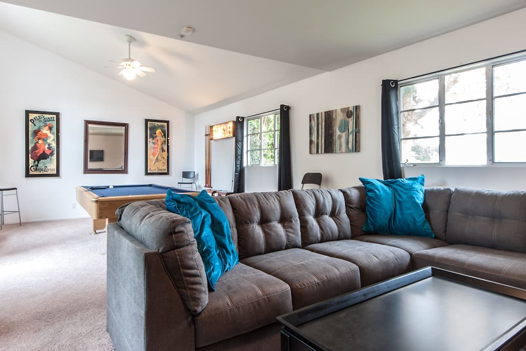 Oversized, comfortable sectional couch and 2 additional club chairs. 4 additional tall chairs around pool table