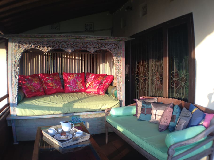 Private balcony featuring an antique carved and hand painted Javanese daybed & Balinese daybed for the enjoyment of sunset drinks or a quiet, comfy spot to relax.