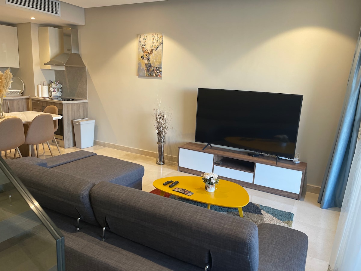 Obývacia izba s peknou krivkou a televízorom s veľkou obrazovkou 