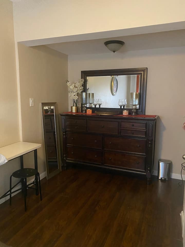 Komoda so zrkadlom v spálni s pracovným stolom a stoličkou. 