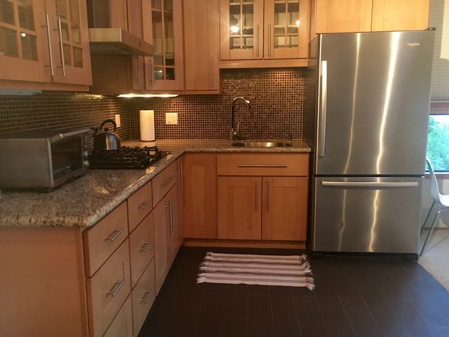 Beautiful new kitchen with 4 burner gas stove, fridge, and toaster oven.