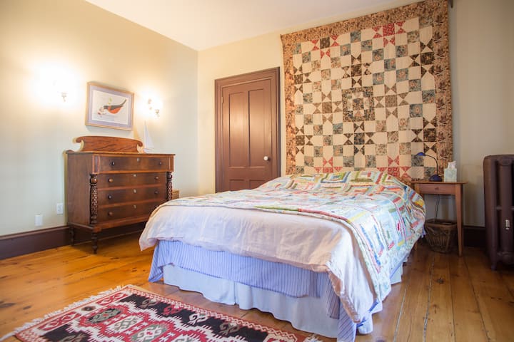 Dormitorio en el segundo piso con cama tamaño queen, vestidor antiguo y armario grande.