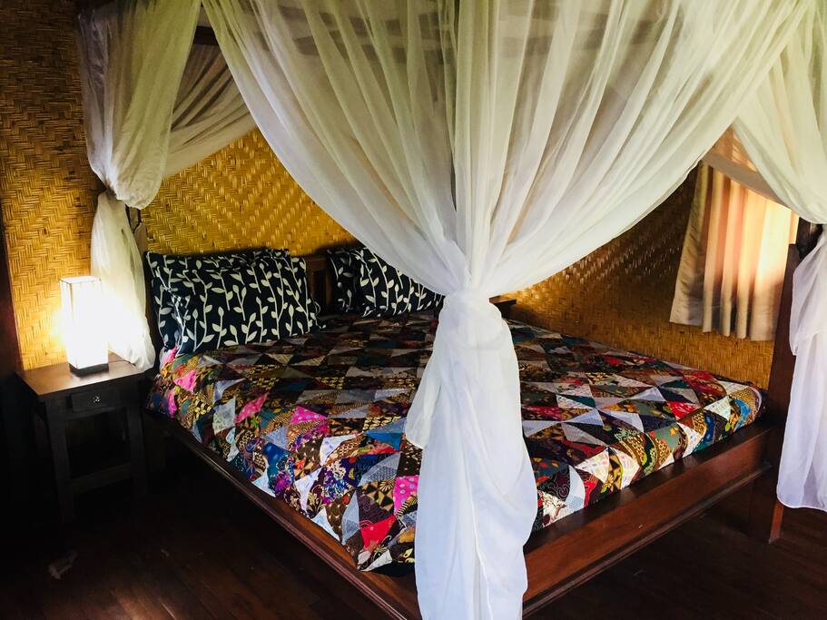 a comfortable bed with mosquito net